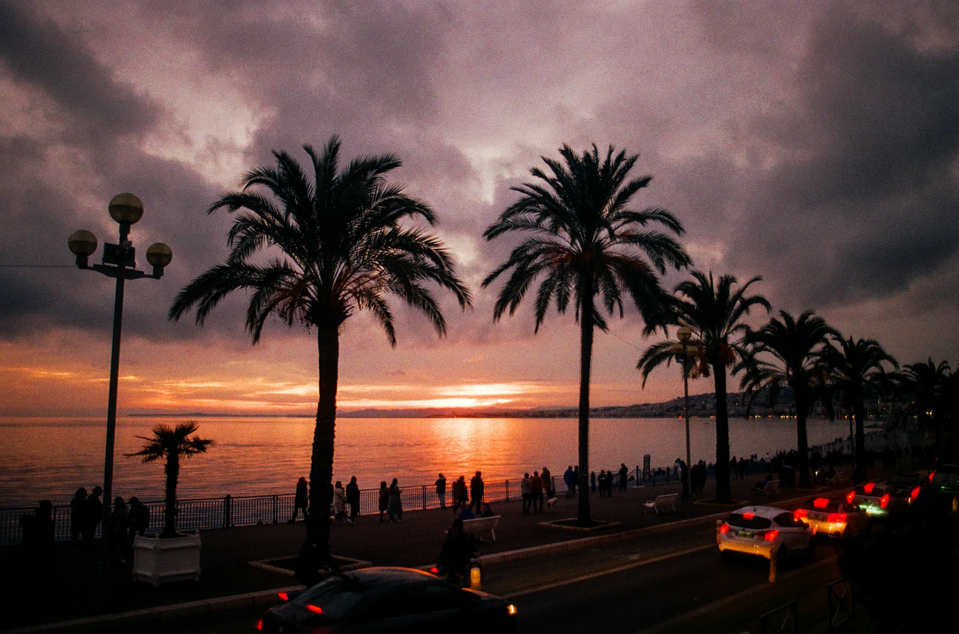 Palms silhouetted against a red sunset on the Promenade des Anglais, Nice