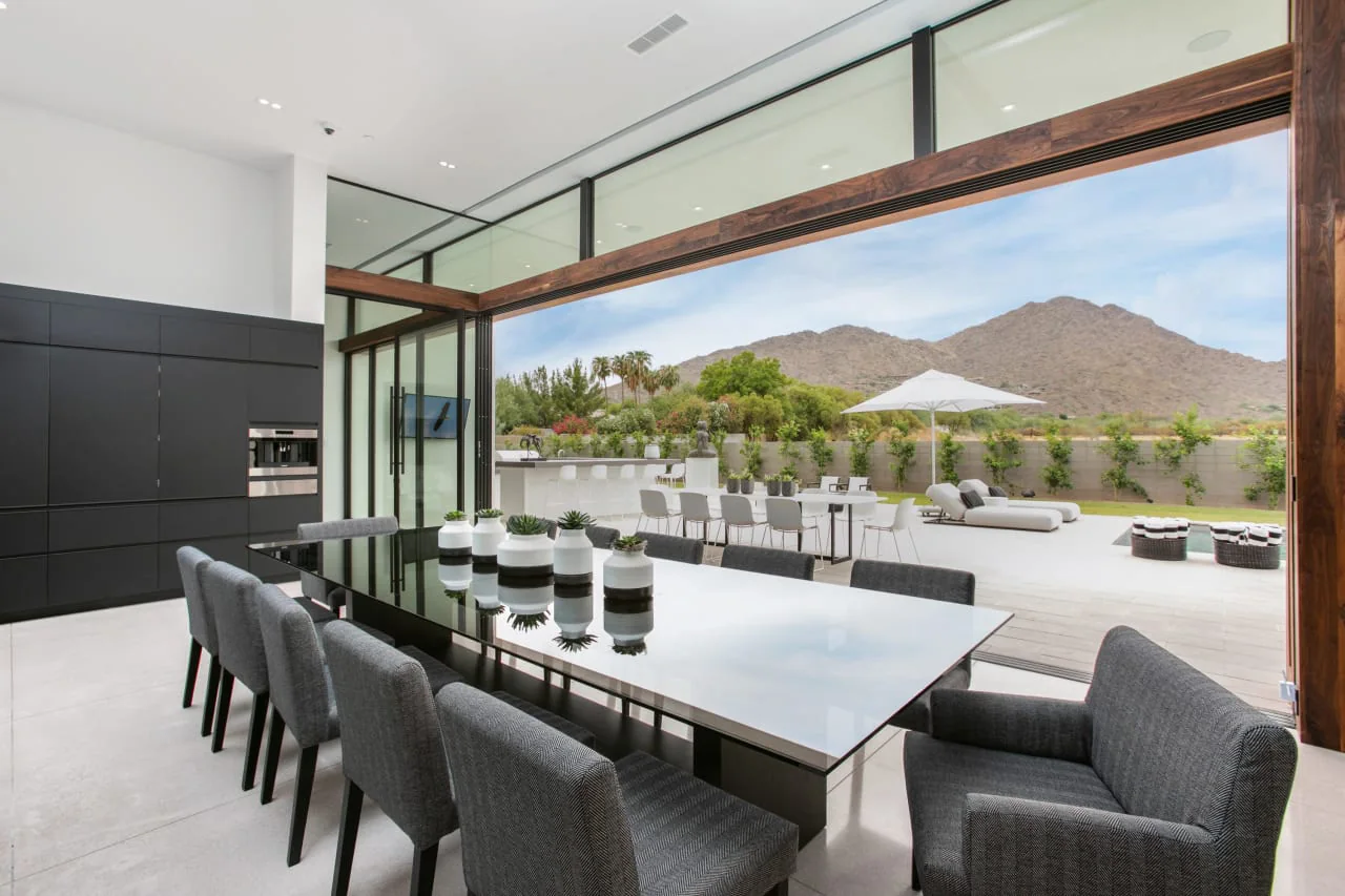 Dining table for twelve with glazing open to the terrace and mountains