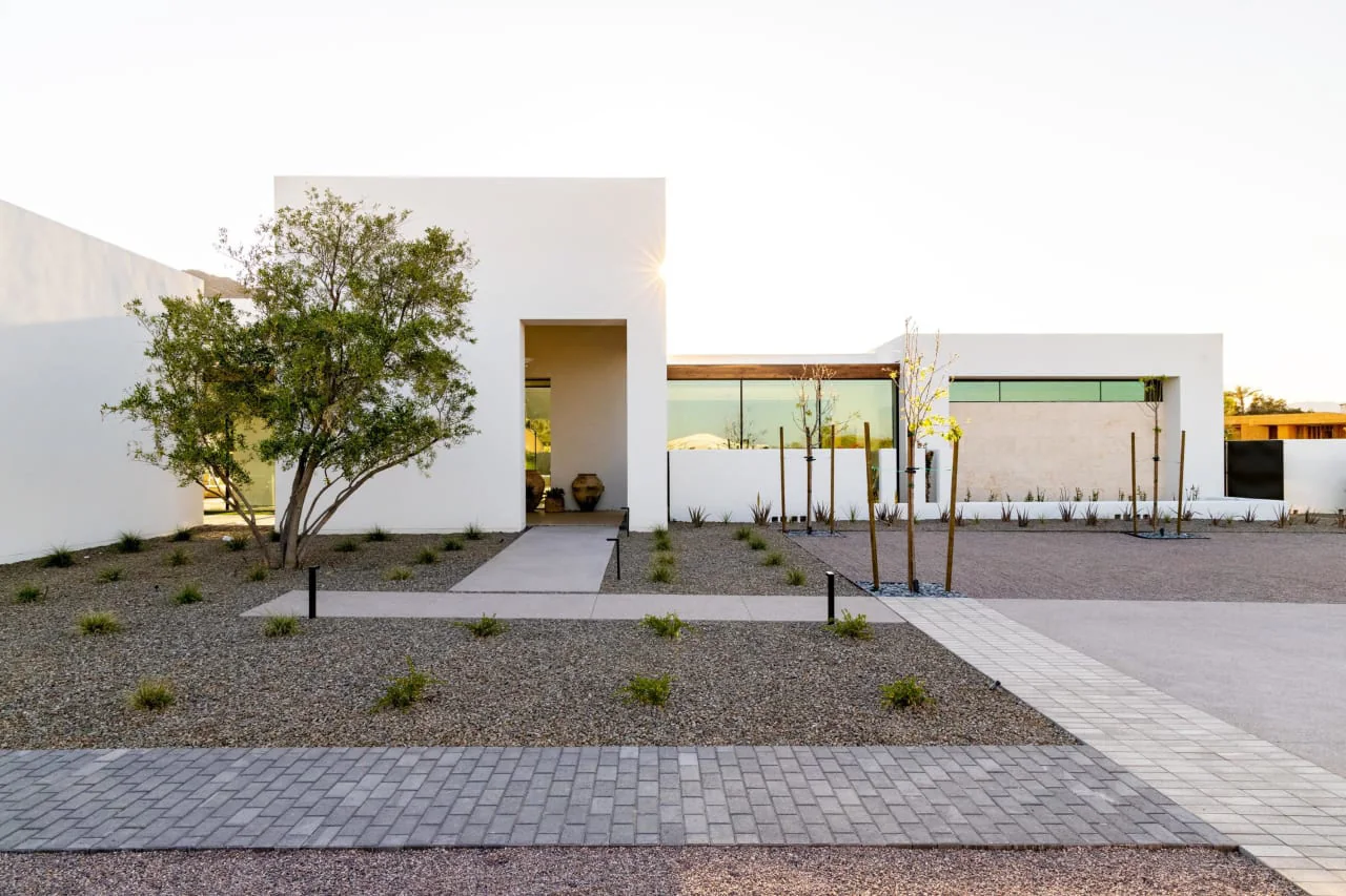 White rendered entrance with a desert garden
